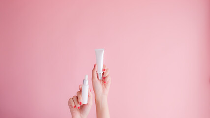 Wall Mural - hand hold cosmetic skincare on pink background.beauty banner.