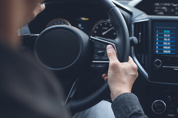 Close up of man turning steering wheel driving a new car