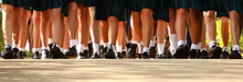 Wide Worms Eye View Multiple Many Female Girls Legs Wearing School Uniform Of White Socks Black Shoes And Tartan Skirt. Walking In Together On The First Day Of High School.