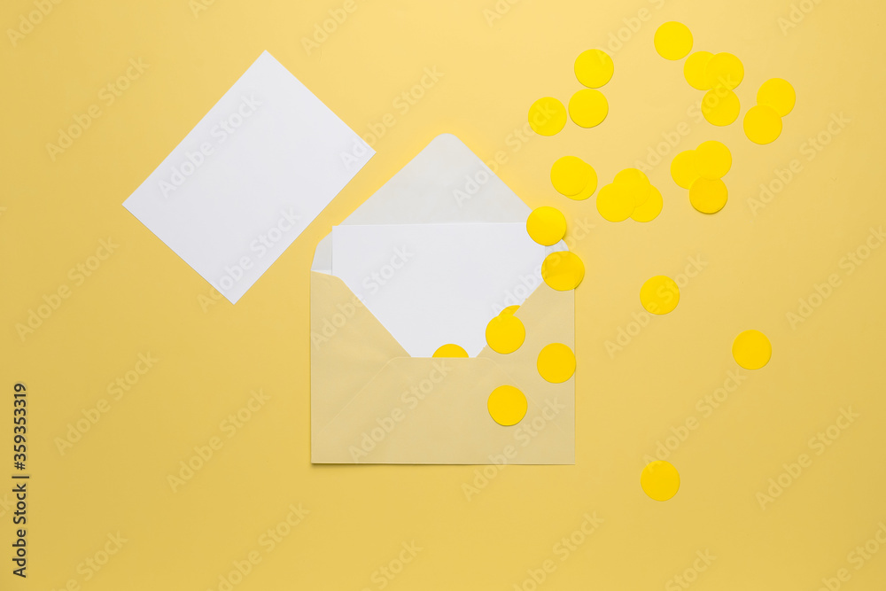 Blank cards with envelope and confetti on color background