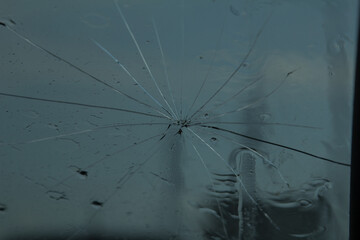  a cracked car windshield after being hit by a rock from an oncoming car