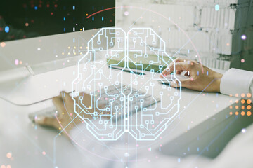 Creative artificial Intelligence concept with human brain hologram and hands typing on laptop on background. Multiexposure