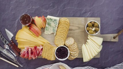 Sticker - Flat lay. Arranging gourmet cheese, crakers, and fruits on a board for a large cheese board.