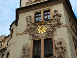 Wall Mural - Very ornate medieval building facade in Europe featuring gold leaf sun with various saints