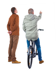 Sticker - Back view of two man on a bicycle in winter jacket.