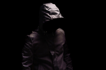 Portrait of Invisible man in the hood on black background.