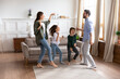 © fizkes - Happy parents with children dancing in modern living room together, family celebrating event, relocation, moving to favorite song, little son and daughter with excited mother and father having fun