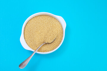 Sticker - couscous in white bowl on blue paper background