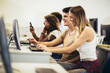 © Mediteraneo - College students sitting in a classroom, using computers during class.
