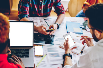 Poster - cropped view of millennial young people working at desktop and using modern smartphones and laptop w