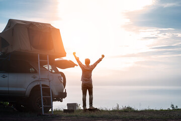 adventurer man in journey travel with off road car and roof tent to enjoy freedom and explorer concept. discover the world living near the power of the nature.