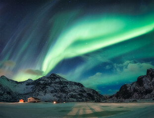Wall Mural - Aurora Borealis or Northern Lights over snowy mountain on Arctic Circle in Flakstad at Lofoten islands