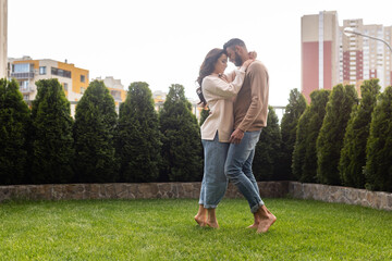 beautiful woman and bearded man standing on green grass