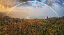 Woman Looking At Rainbow. Rainbow Over The Autumn River