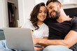 © LIGHTFIELD STUDIOS - happy woman holding credit card near bearded boyfriend and laptop