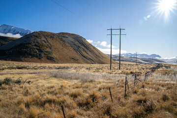 Wall Mural - Fence Along Country Road on Sunny Morning with snow mountain.