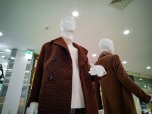Two Female Mannequins Demonstrate Brown Coats In A Women's Store