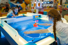Girls Playing Air Hockey In Entertainment Center