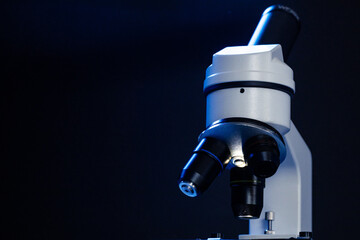 Microscope with lenses close up against dark background