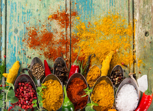 Photo Various colorful spices on wooden table, top view.