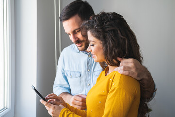 Wall Mural - Couple using mobile phone together stock photo