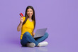 © Prostock-studio - Online Payments. Asian girl sitting on floor with credit card and laptop