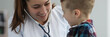 © H_Ko - Close-up of smiling doctor examine child lugs. Lovely female doctor in medical gown wearing stethoscope. Modern medicine and pediatric appointment concept