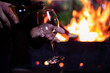 © Владимир Сидоров - pour a glass of white wine from a bottle on the background of a barbecue with fire