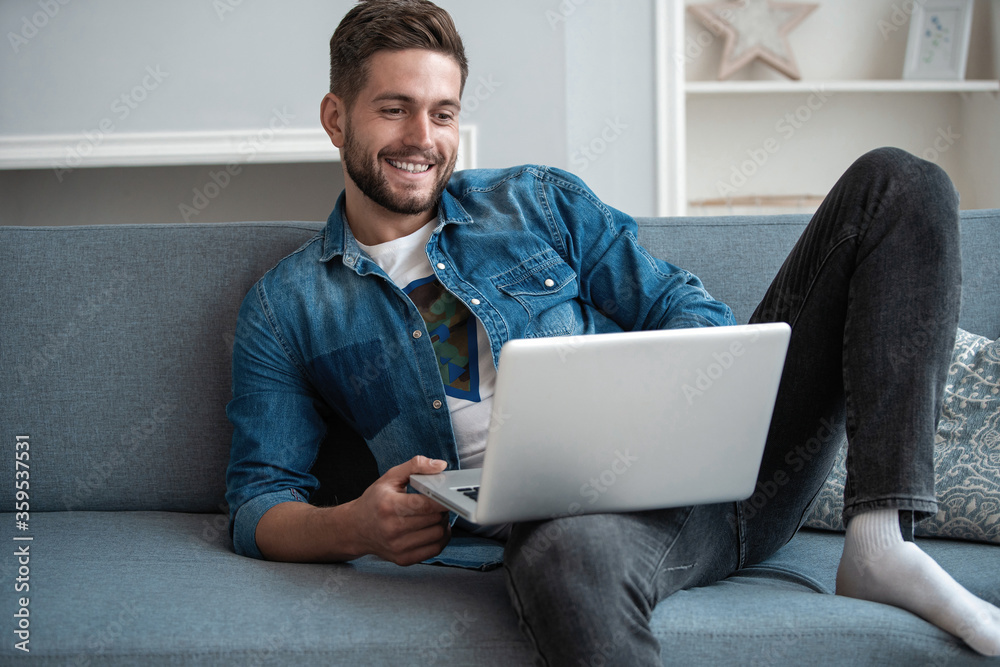 Getting Out Video Call Smiling young man making video call with friends at his modern home ...