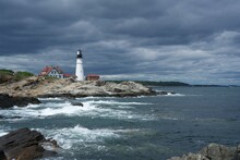 Portland Head Light Lighthouse In Maine Under Dark Clouds And Crashing Waves