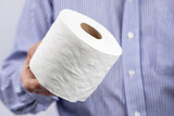 Fototapeta Morze - closeup of a man holding a roll of toilet paper