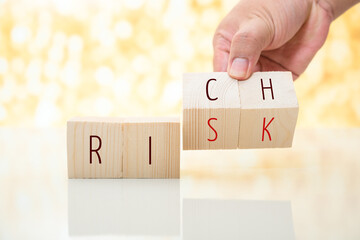 man hand change wood cube block from rich to risk