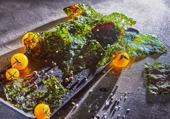 Sticker - Crispy nori seaweed with cherry tomatoes and dark spices on gray concrete. Japanese food nori. Dried sheets of seaweed. Copy space