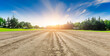 © ABCDstock - Rural dirt road ground and green forest at sunrise.