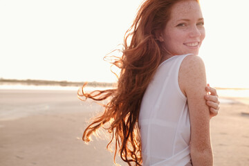 Beautiful young lady with long healthy red hair and cute dress