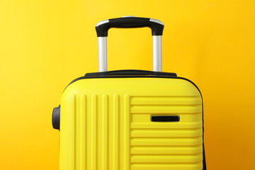 Wall Mural - Color travel bag on yellow background, close up