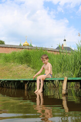 Wall Mural - Swiming happy tourist little boy, child in Suzdal town, Vladimir region, Russia. Active recreation, rest, relax in summertime. Summer travel in Russia. National domestic tourism. Happy childhood