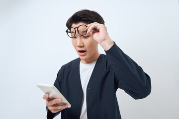 Wall Mural - Young man looking agitated at display of him smartphone, impressed by media content from web