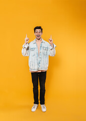 Canvas Print - Photo of delighted young man in eyeglasses pointing fingers upward