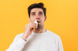 Photo of sick unhappy man with allergy using drops and sneezing