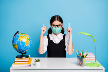 Poster - Portrait of her she nice attractive genius brainy diligent girl in reusable mask sitting showing forefingers up copy space ad isolated on bright vivid shine vibrant blue color background