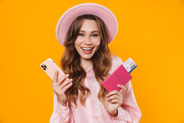 Canvas Print - Image of laughing woman holding passport with ticket and mobile phone