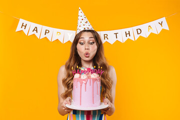 Poster - Image of happy young woman blowing out candles on birthday torte