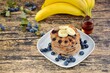 Homemade banana blueberry pancakes on wooden background