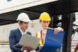 © winnievinzence - Asian man logistic foreman using laptop working at warehouse construction site with woman worker. import export or shipping delivery business. planning and strategy. copy space