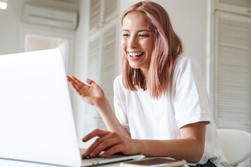 Cheerful young girl using laptop computer