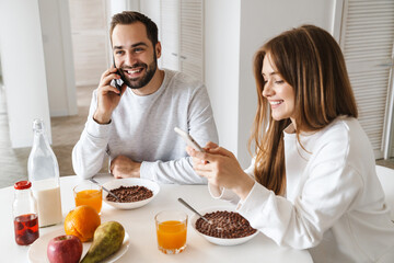 Wall Mural - Cheerful young couple having tasty breakfast