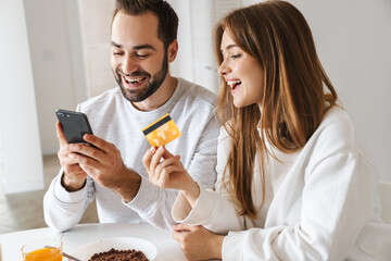 Poster - Cheerful young couple having tasty breakfast