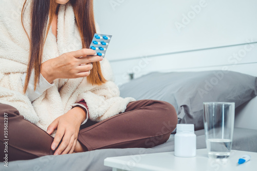 Sick asian woman taking medicines, painkiller or antibiotic. Young lady drinking  Pharmacy and healthcare concept