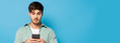 © LIGHTFIELD STUDIOS - horizontal image of serious young man chatting on smartphone on blue